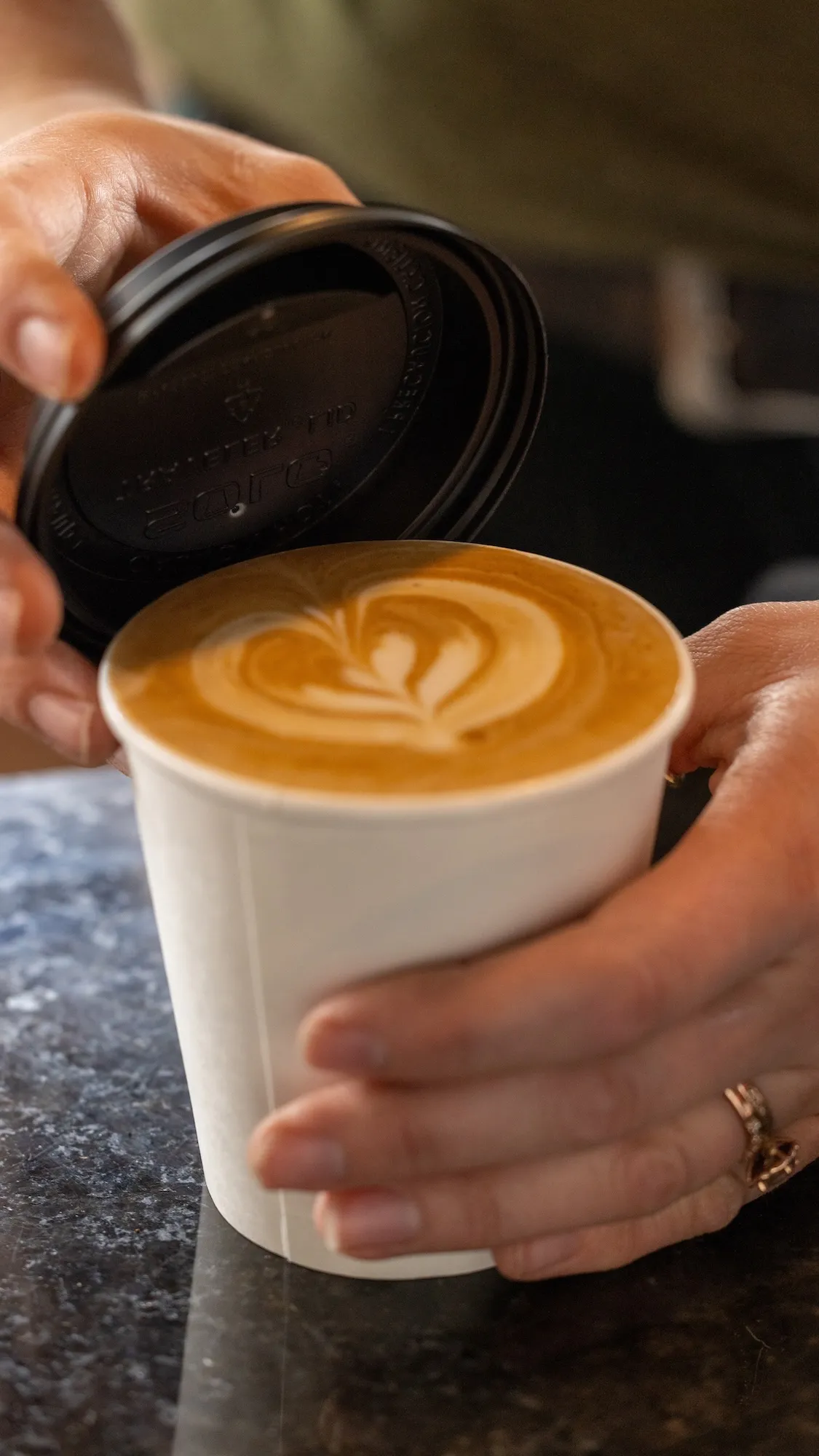 Barista holding a freshly made latte to go