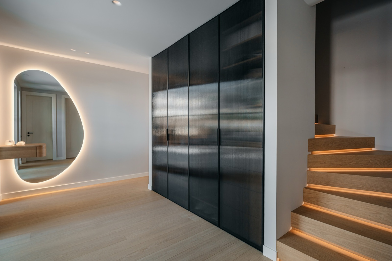 Aphrodite House by COBALT, Aphrodite Hills, Cyprus - hallway with backlit mirror and stairs