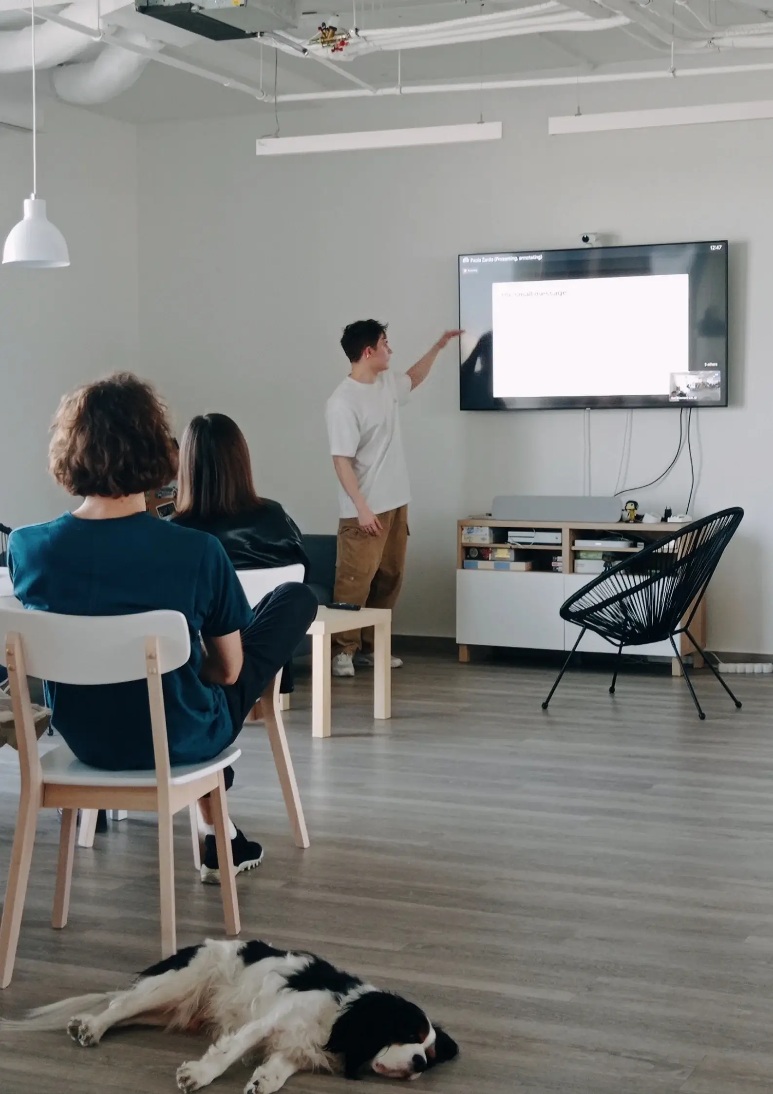 A presentation at UX studio's spacious kitchen, with a dog laying in the foreground