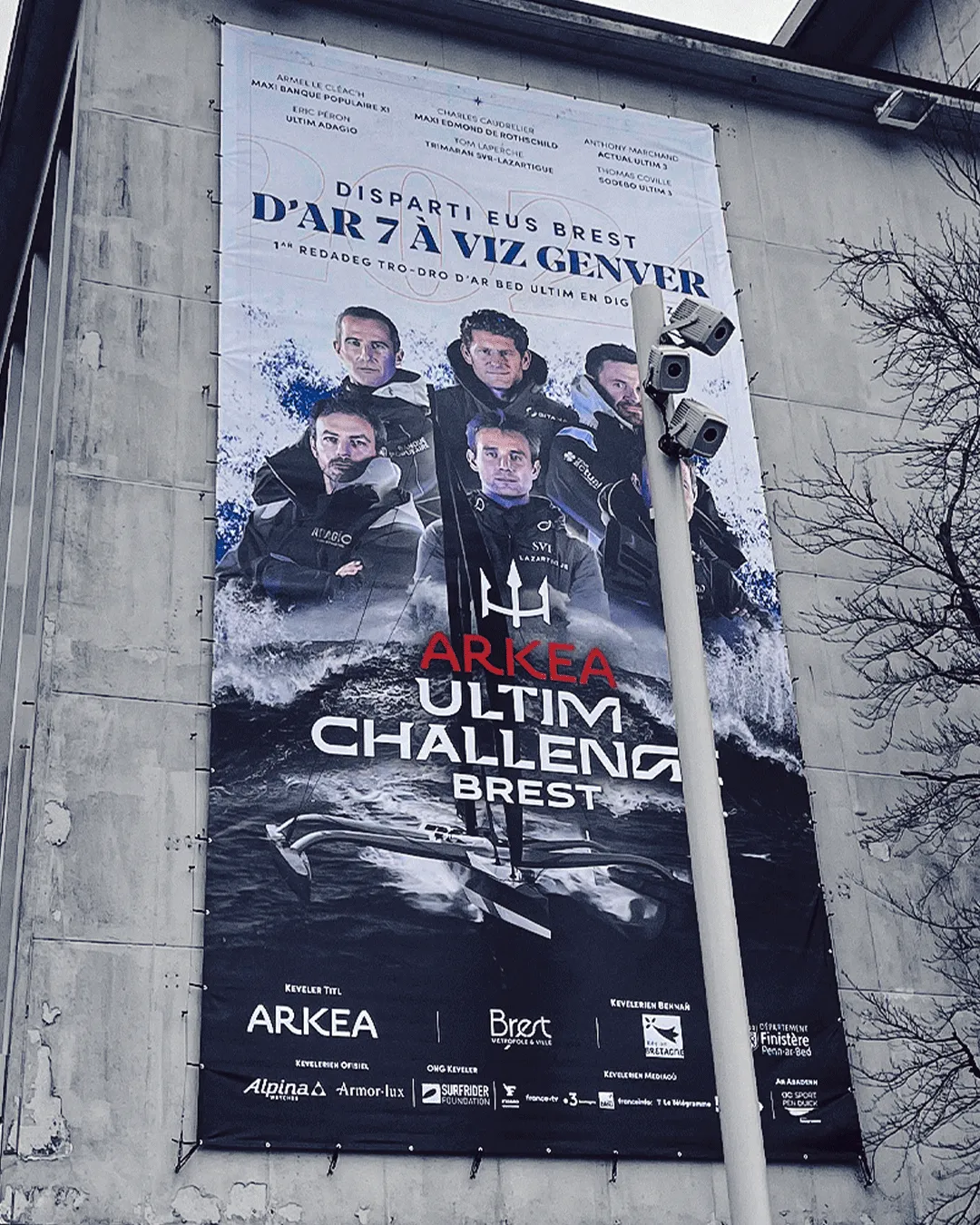 Affiche grand format de l'Arkea Ultim Challenge installée sur une façade à Brest
