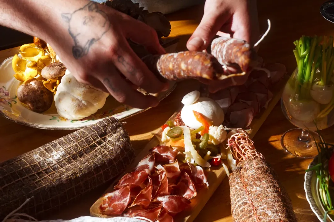 Le chef prépare une planche de charcuteries et burrata au Bistro Le Louis XVI