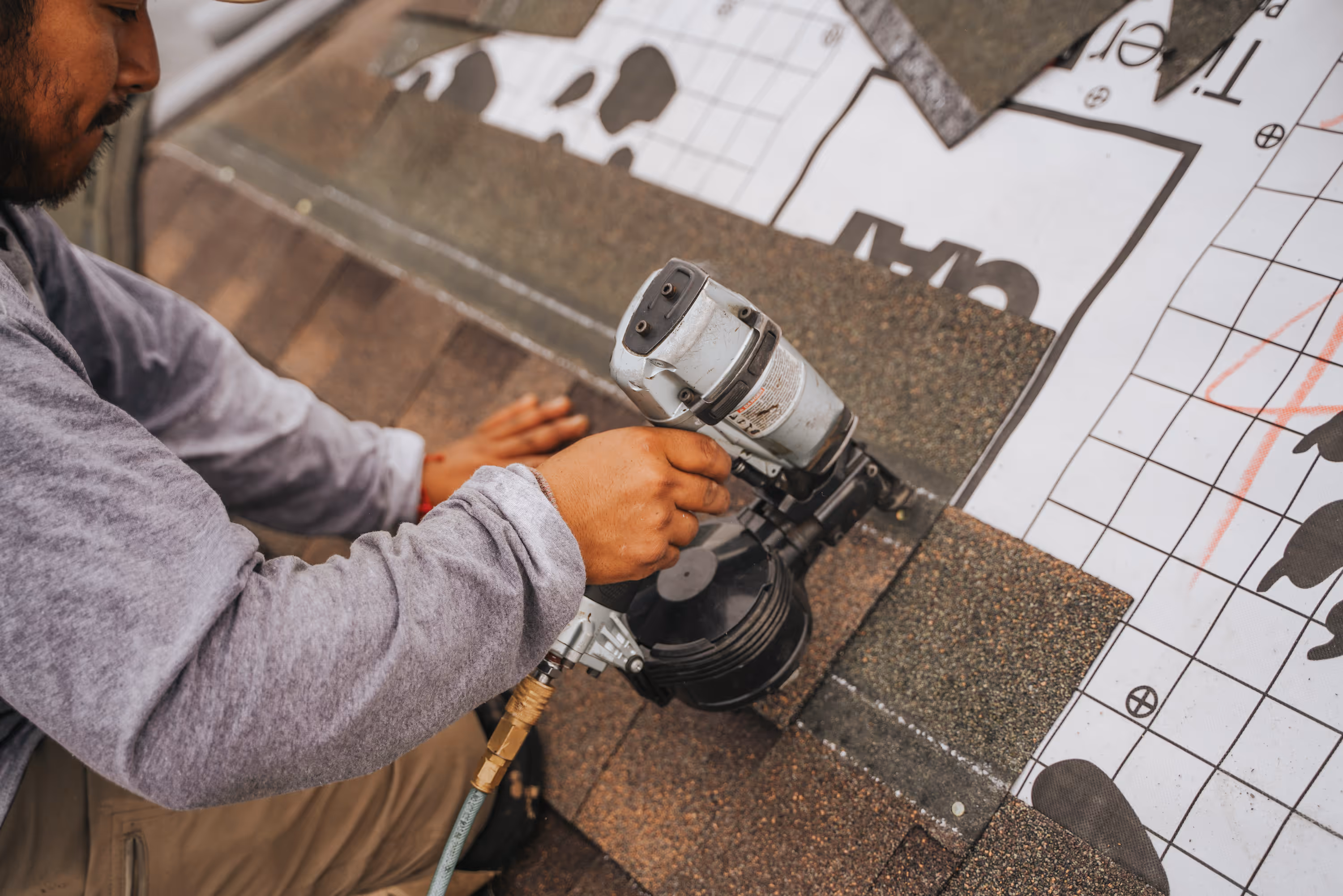 roof repair installing asphalt shingles with nail gun