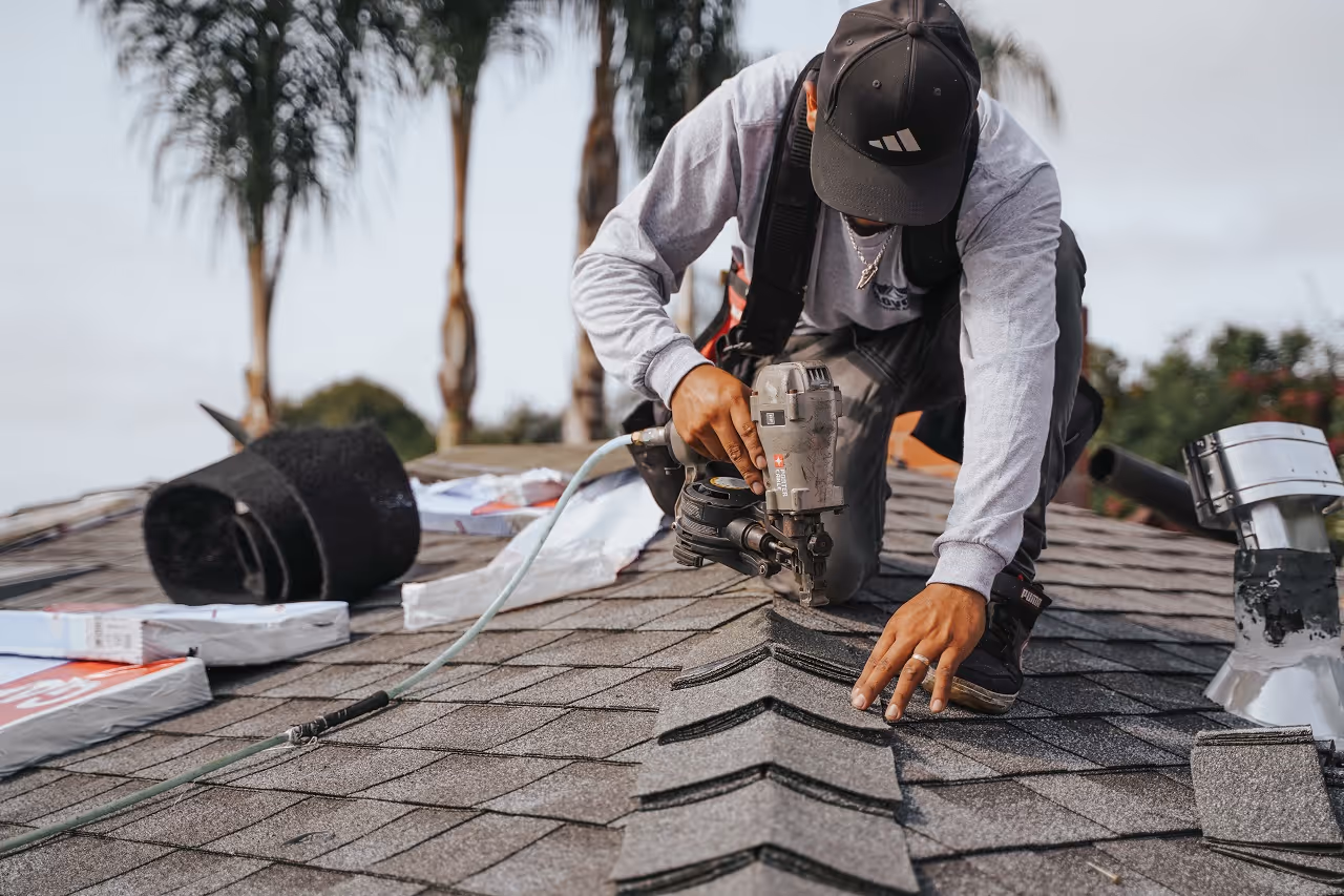 roofing contractor installing asphalt shingle ridge