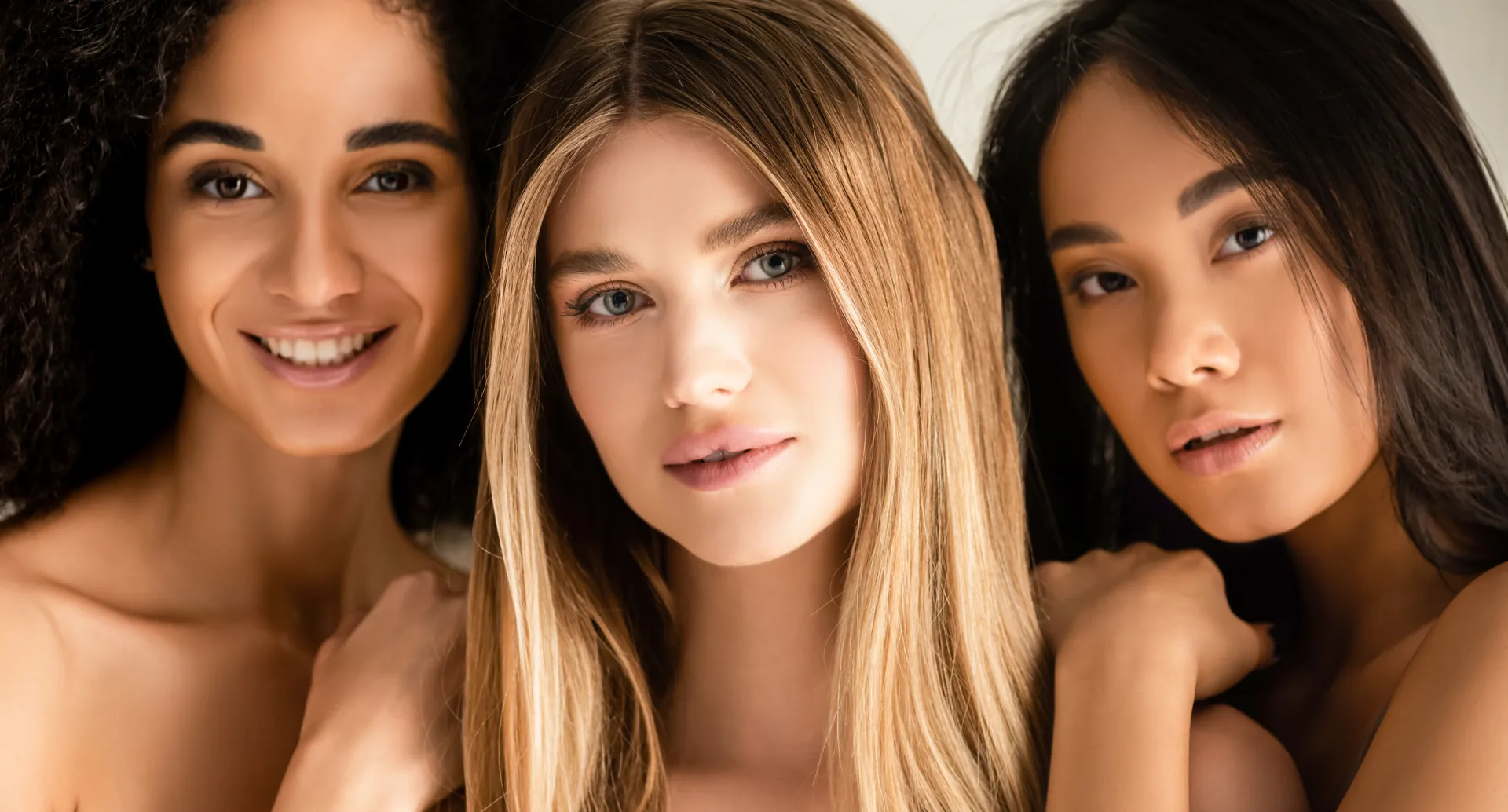 Three women, embracing each other.