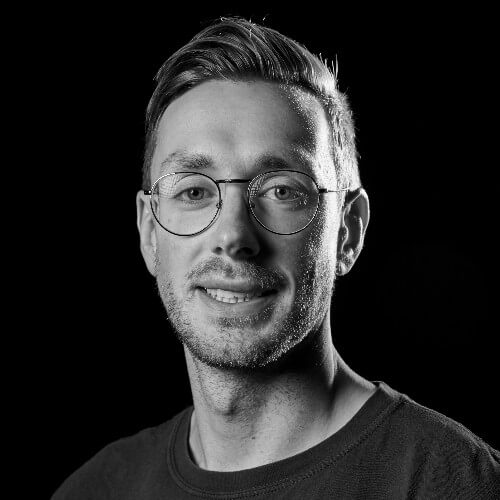 A photo of a man smiling in black and white.