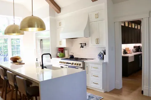 White kitchen island with overhead lighting