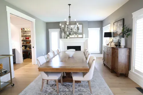 Dining room space with wooden table and white cloth chairs