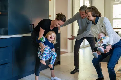 Family in kitchen together, dancing