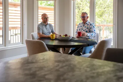 Far away view of homeowners sitting together at table