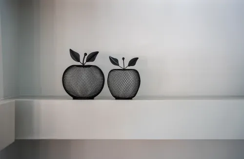 Close up shot of two decorative wire apples on built in shelving
