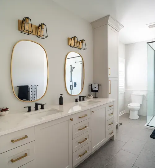 Ensuite bathroom double sinks with black accents and gold rimmed mirrors