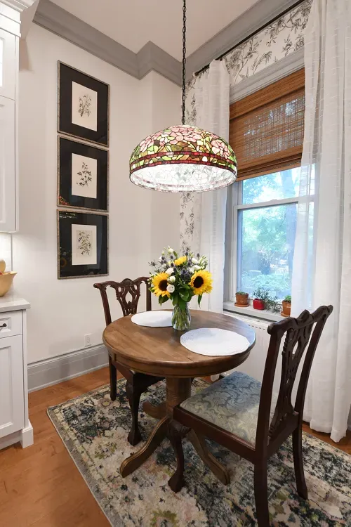 Breakfast nook with round wooden table and stained glass lamp