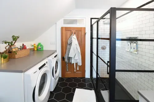 Washroom with glass shower, washer, and dryer