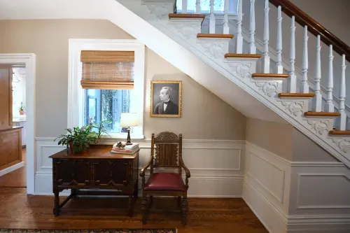 Foyer chair and side table against staircase wall