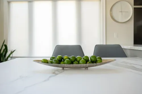 Decorative bowl of limes on kitchen table