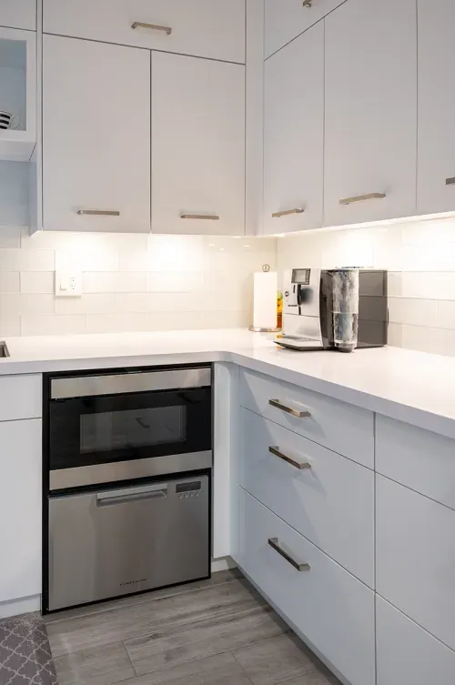 White kitchen cabinetry and stainless steel oven
