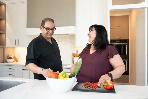 Homeowners laughing together at kitchen island