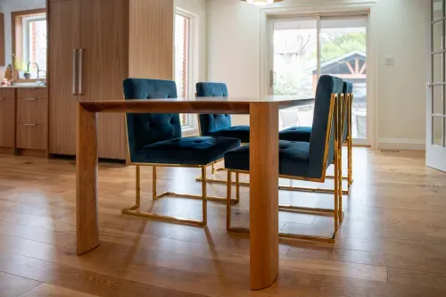 Custom wooden dining table with stylish velvet blue chairs
