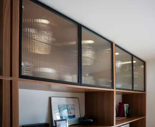 Close in of custom wooden cabinetry along kitchen wall