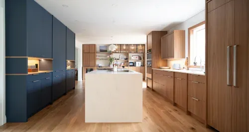 Full view of kitchen layout with navy blue and natural wood cabinetry