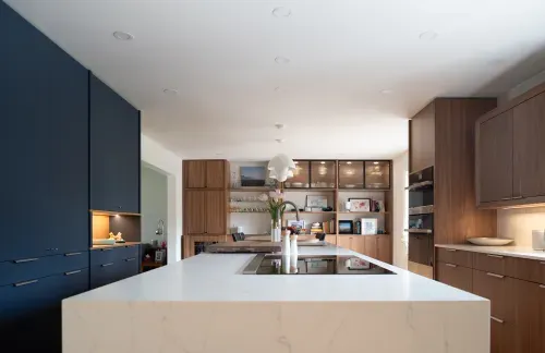 Straight view of kitchen layout with custom cabinetry along three walls, white island in middle
