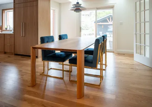 Custom wooden dining table with four modern velvet chairs