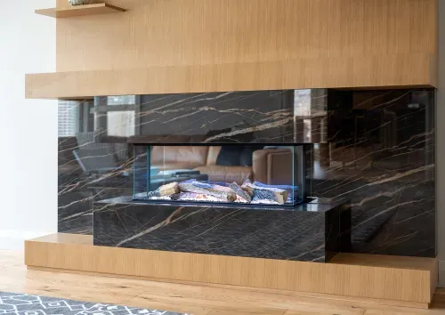 Angled view of modern electric fireplace with marble face and wooden accents