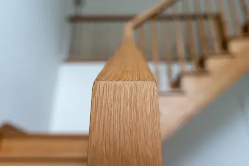 Detailed close up of wooden staircase railing facing front