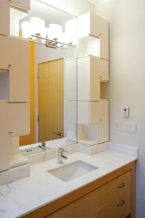 Modern bathroom with wooden counter, with white sink and large wall mirror