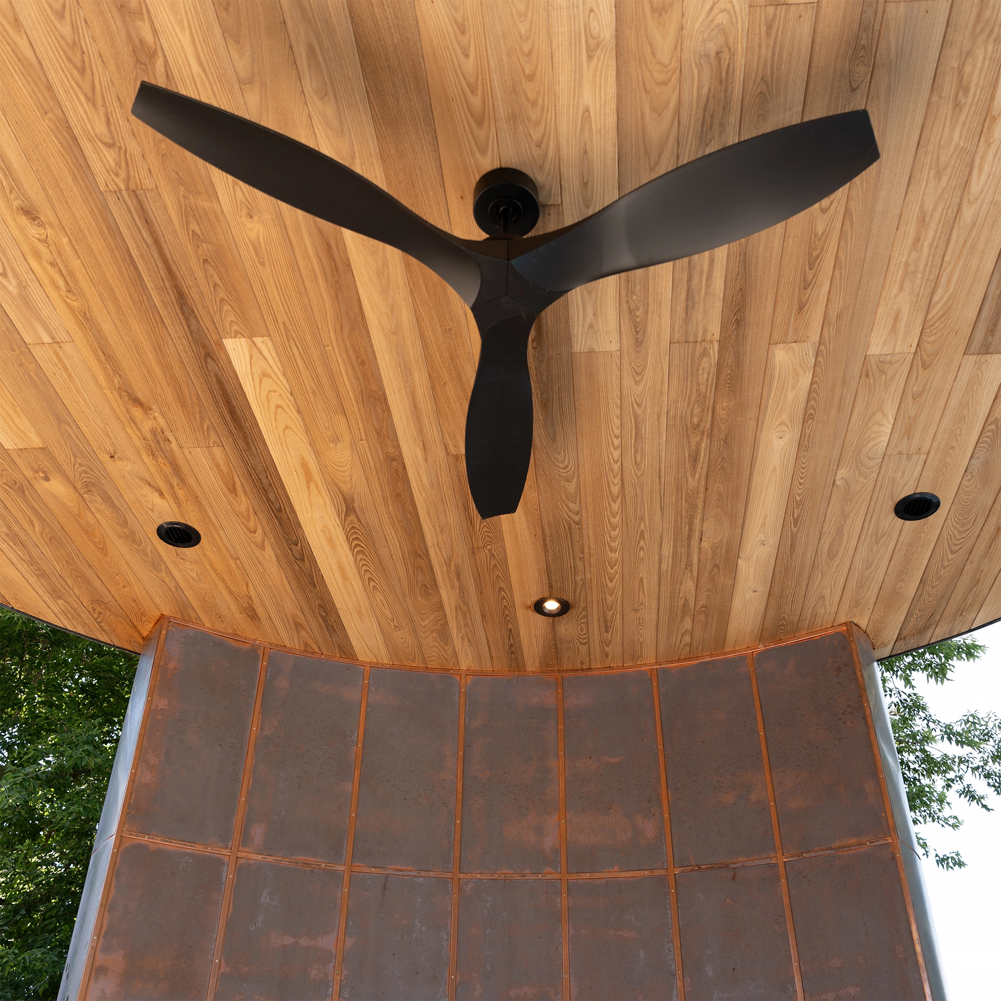 Upwards view of open-air rotunda with ash clad ceiling and copper accent wall