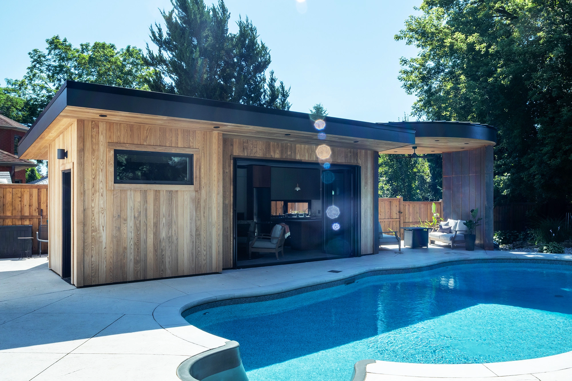 Exterior of pool house with bright blue pool in foreground