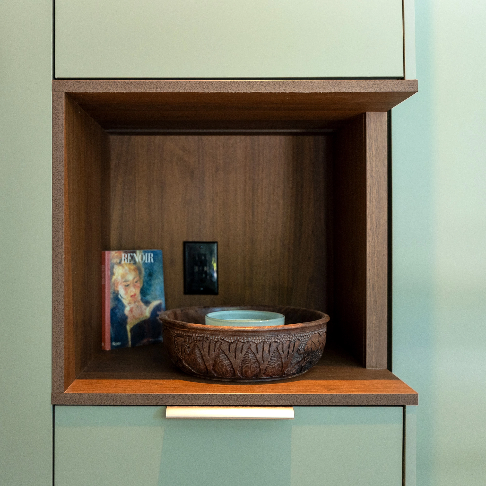 Close up detail shot of built-in shelving with wooden details on wall of sitting area.