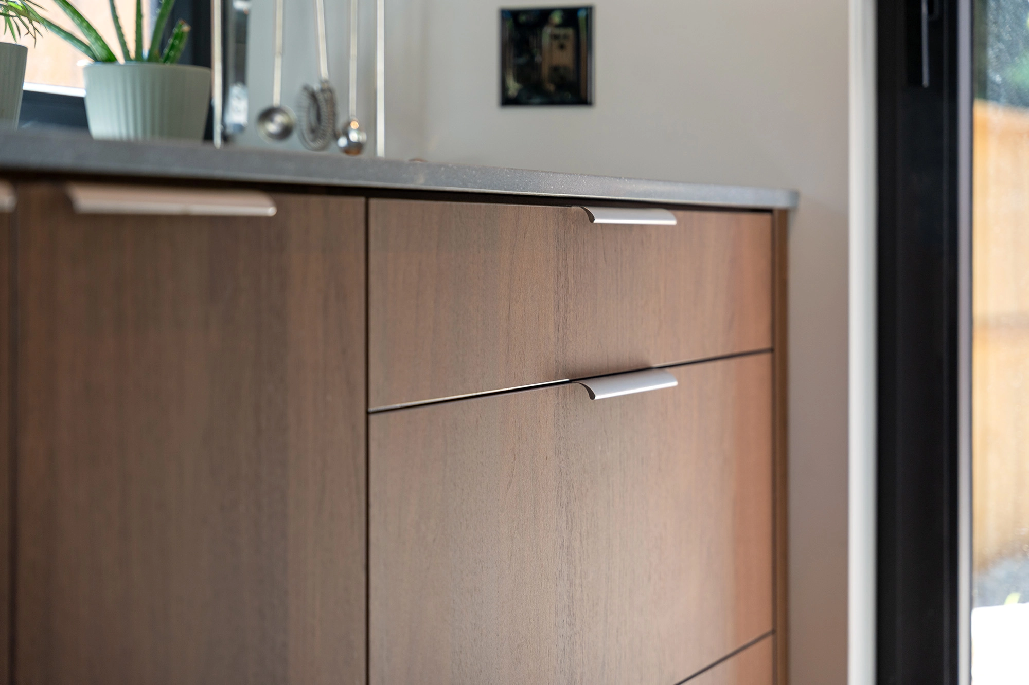 Close up view of modern wooden kitchenettecabinetry and drawer pulls