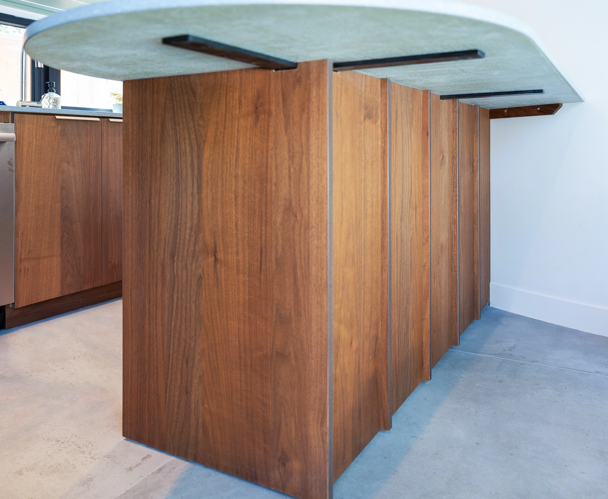 Detail shot of kitchenette island countertop, with wooden base and detailing along the countertop edge