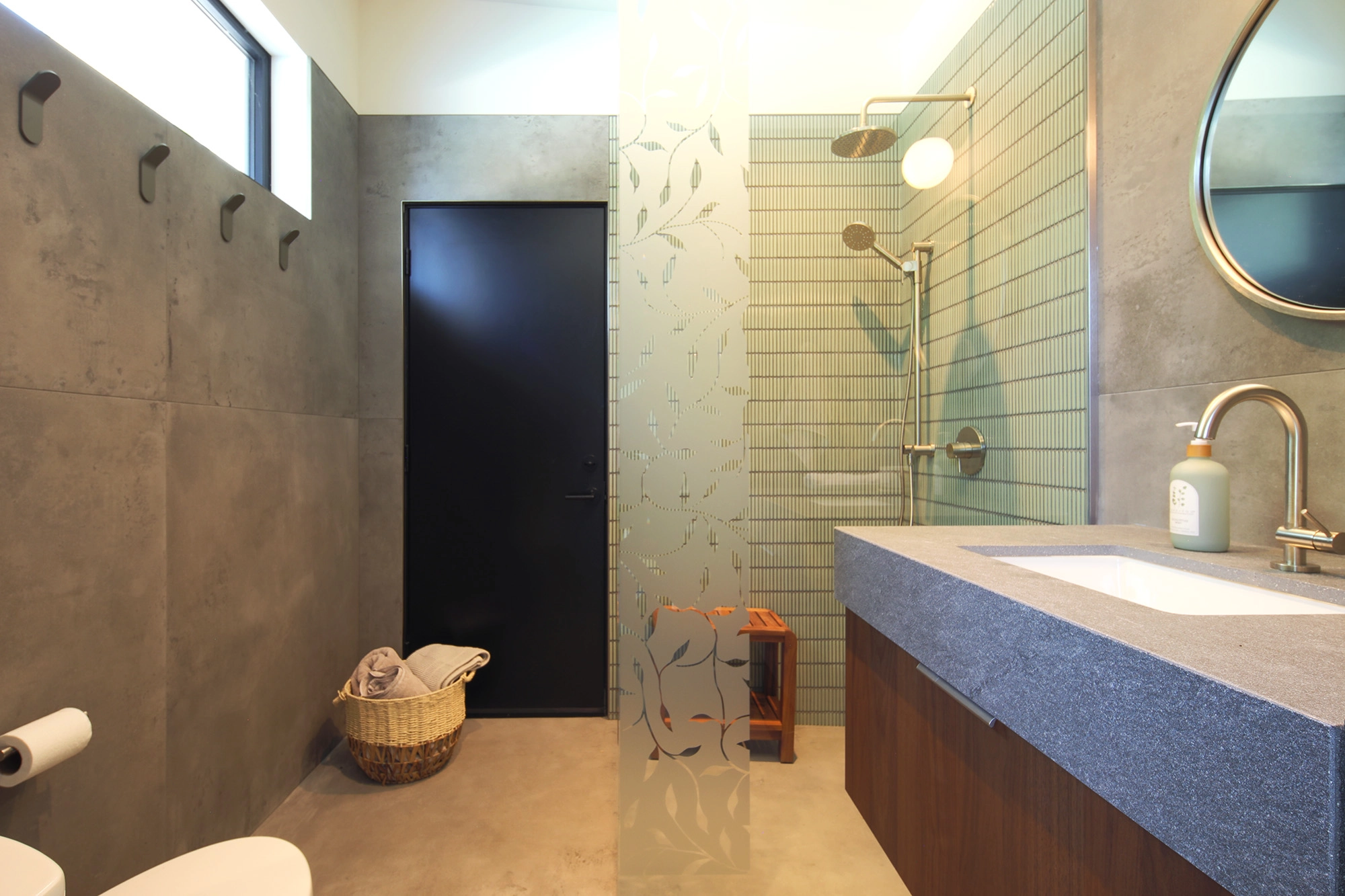 Poolhouse bathroom space with modern sleek lines, green tile shower, and rectangular window