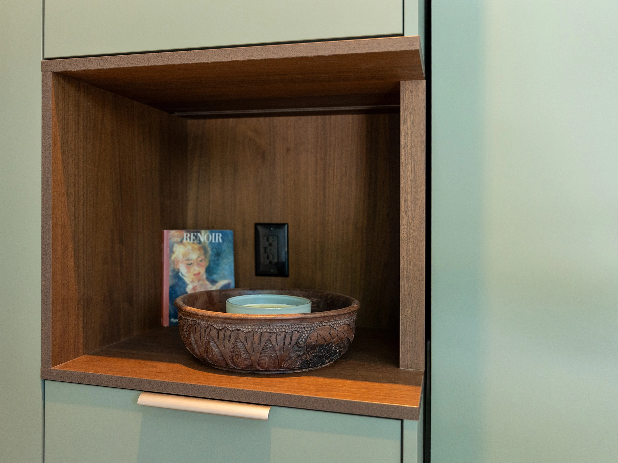 Detail shot of recessed wall cabinetry in poolhouse sitting area with decorative shelving
