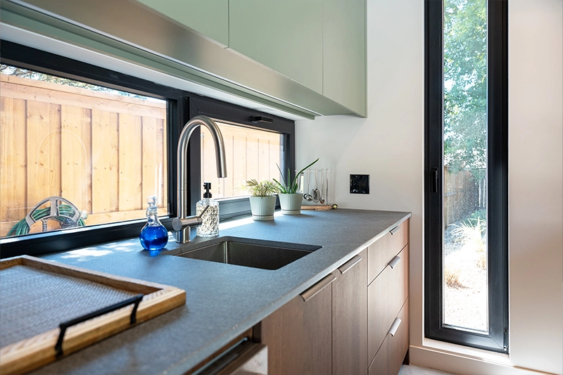 Detail shot of kitchenette sink and cabinetry in poolhouse