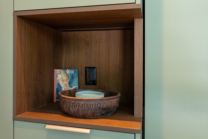 Close up detail shot of built-in shelving with wooden details on wall of sitting area.