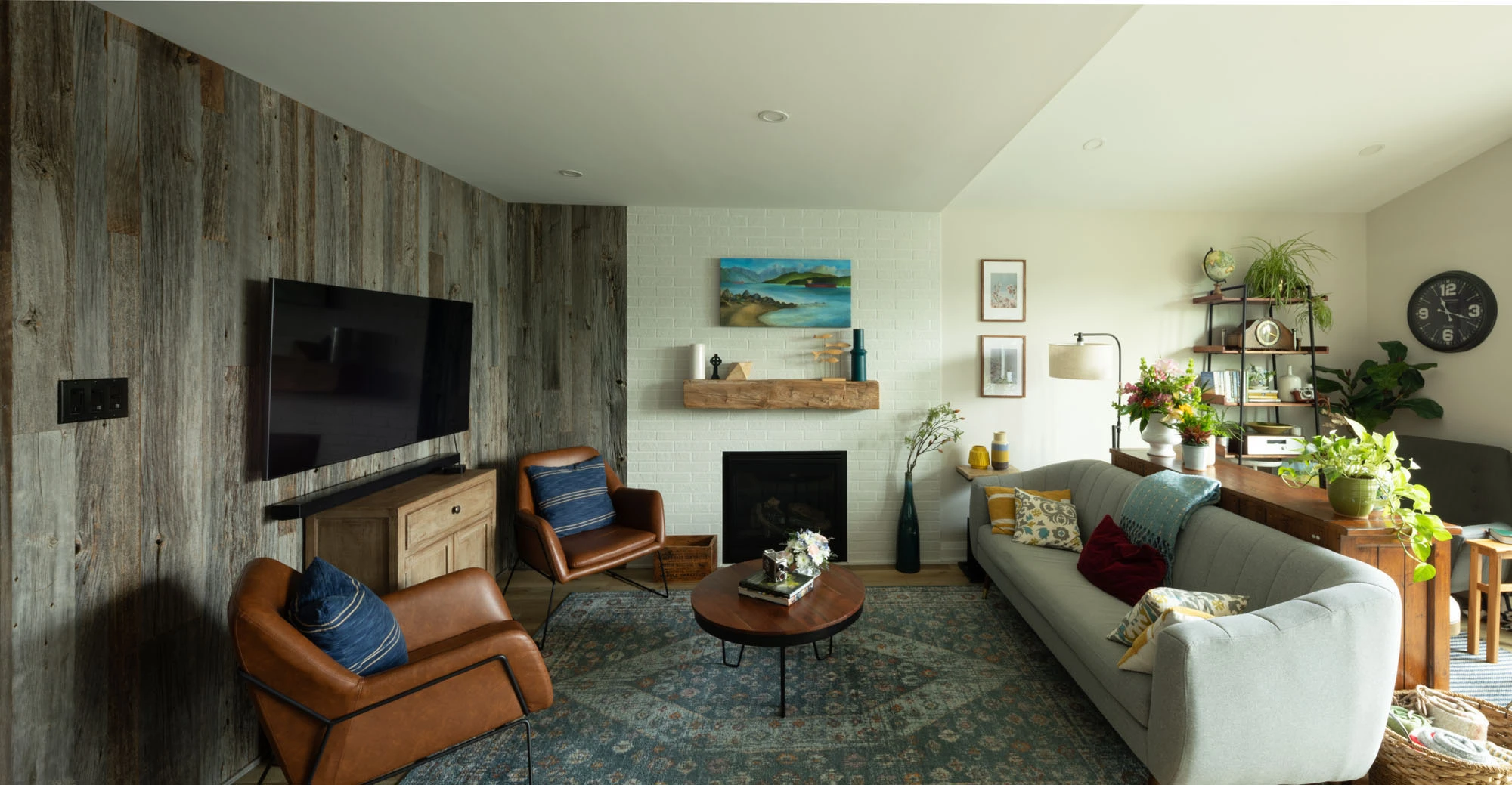 Living room area with seating, television, fireplace, and shelving