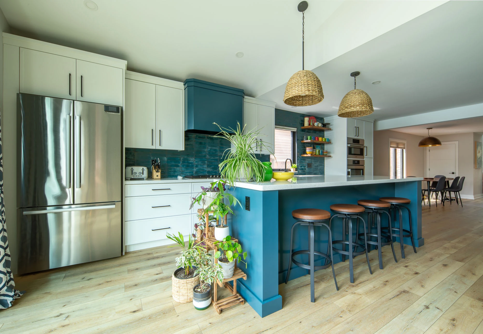 Bright kitchen space with blue cabinetry, large kitchen island, and stainless steel appliances