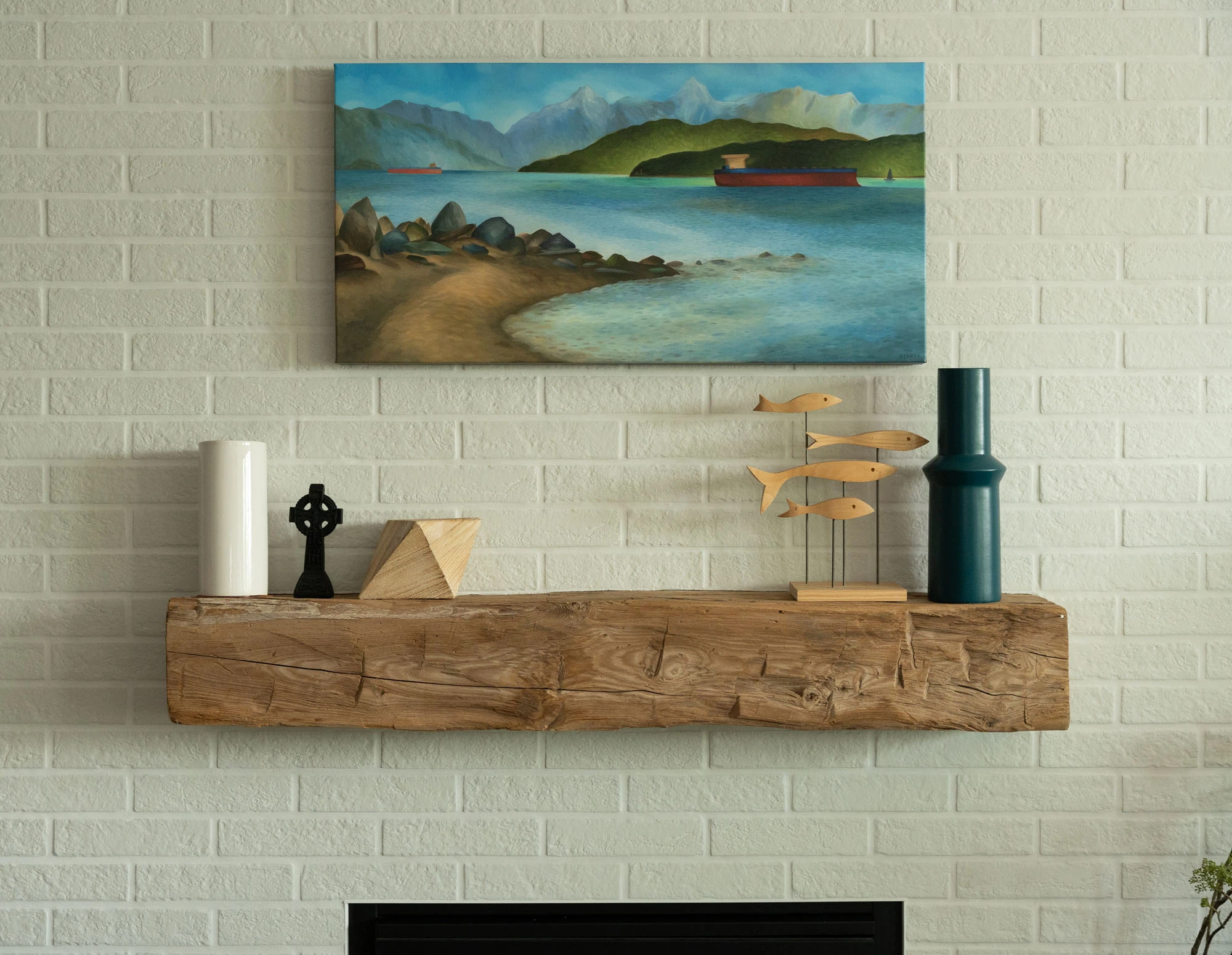 Living room mantle above fireplace with painting and decorative items perched on top
