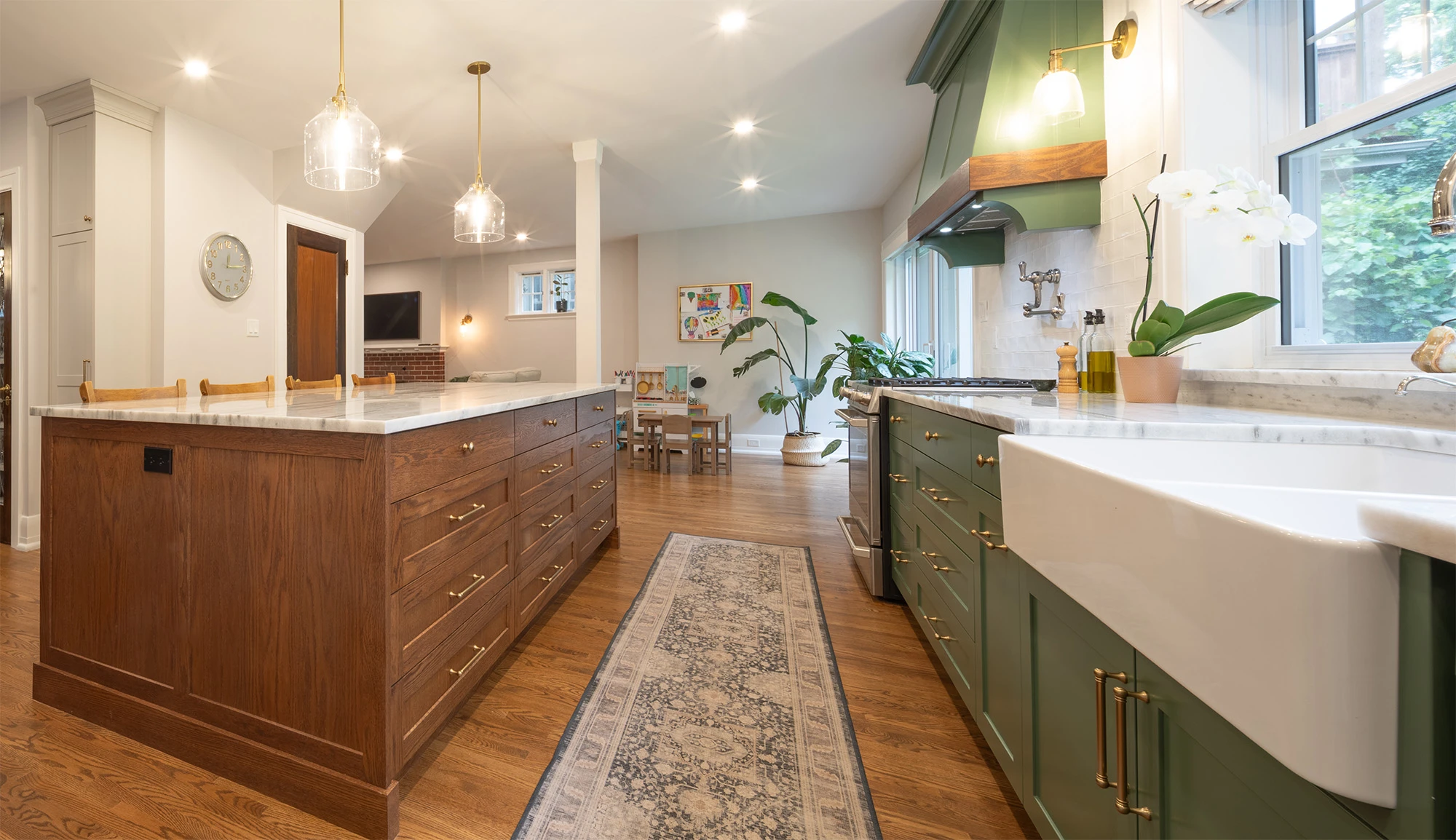 Brightly lit open-concept kitchen with solid wood flooring and cabinetry, granite countertops