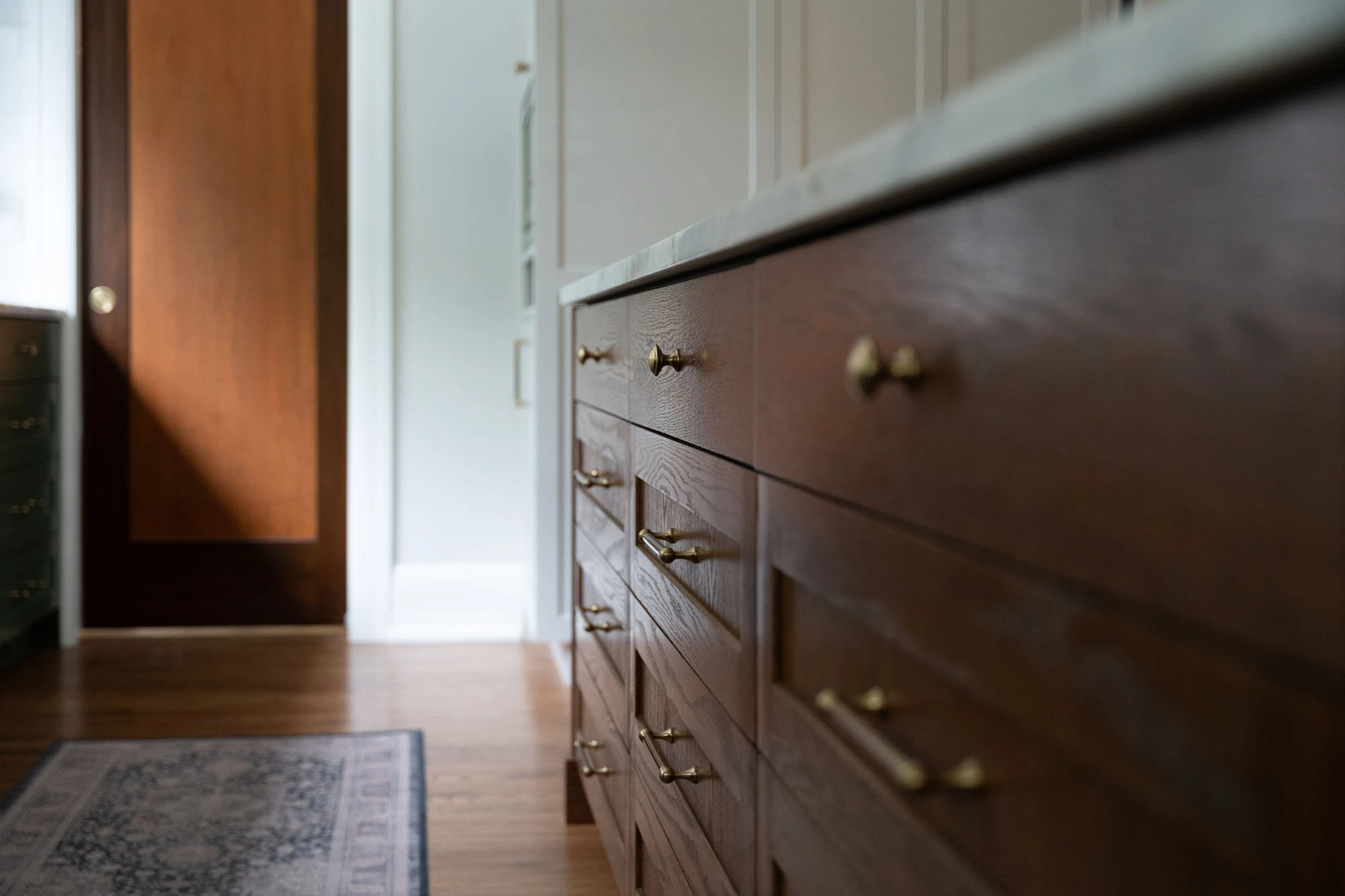 Details of solid wood kitchen cabinetry with brass handles and drawer pulls