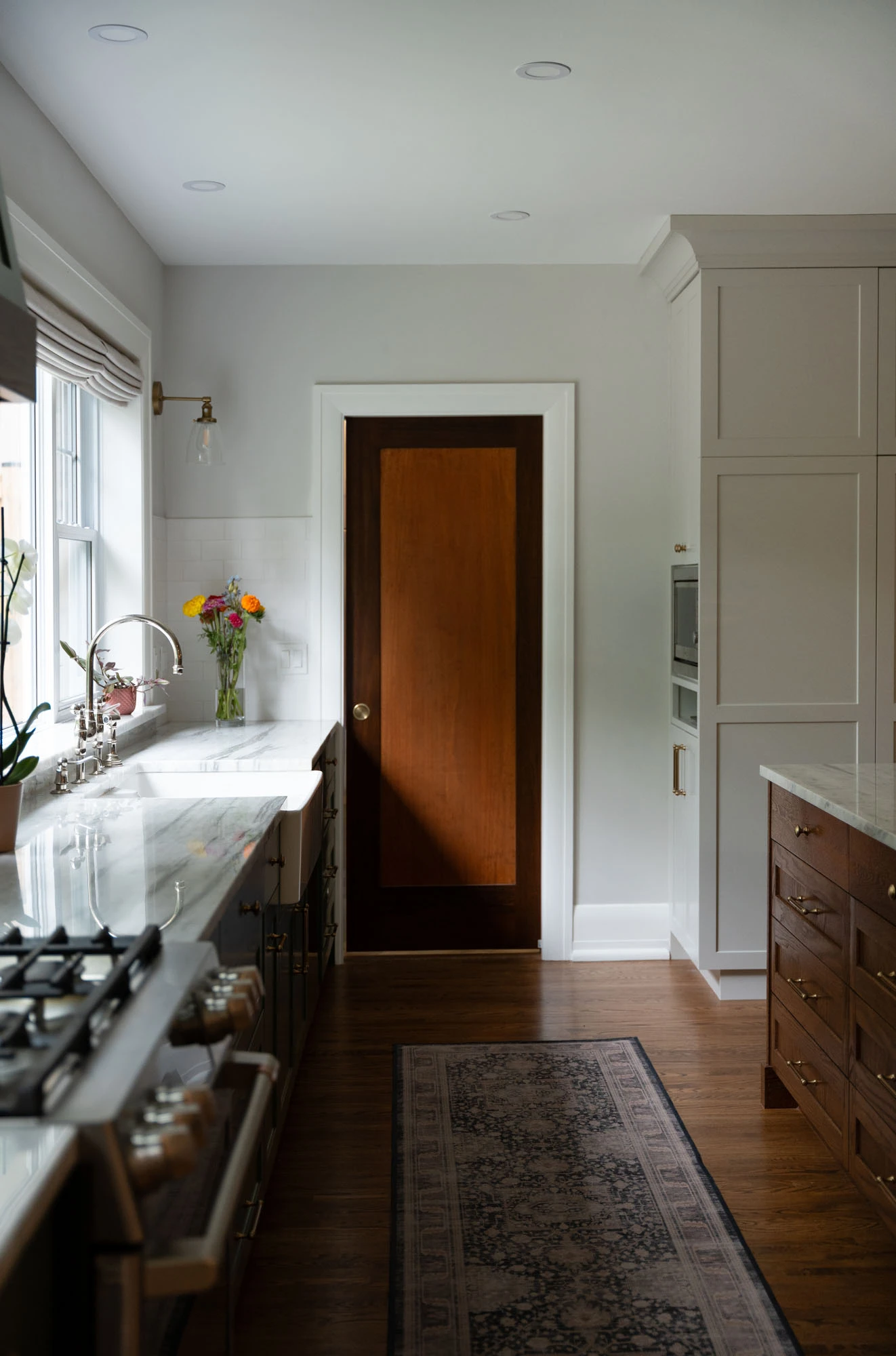 Natural light streaming in from kitchen window and casting dramatic shadows on hardwood flooring.