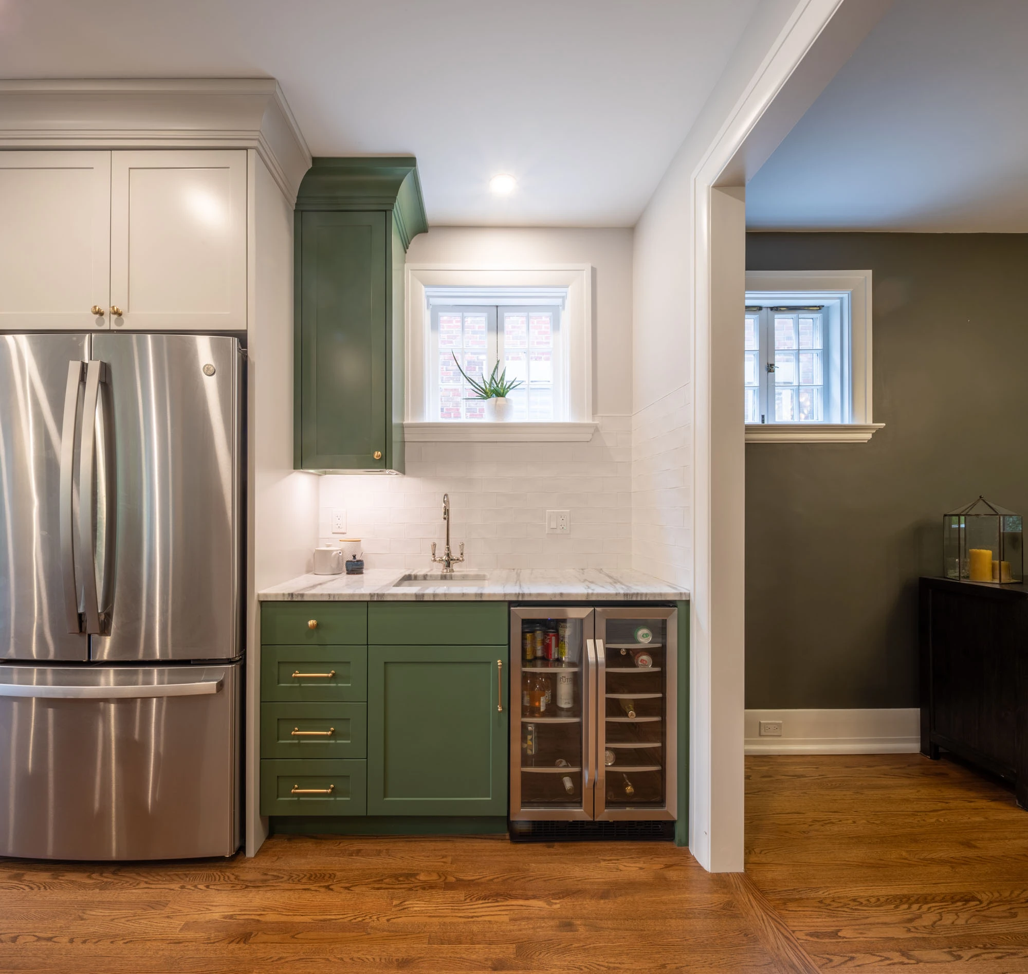 Stainless steel fridge, white and green painted cabinetry and mini-fridge.