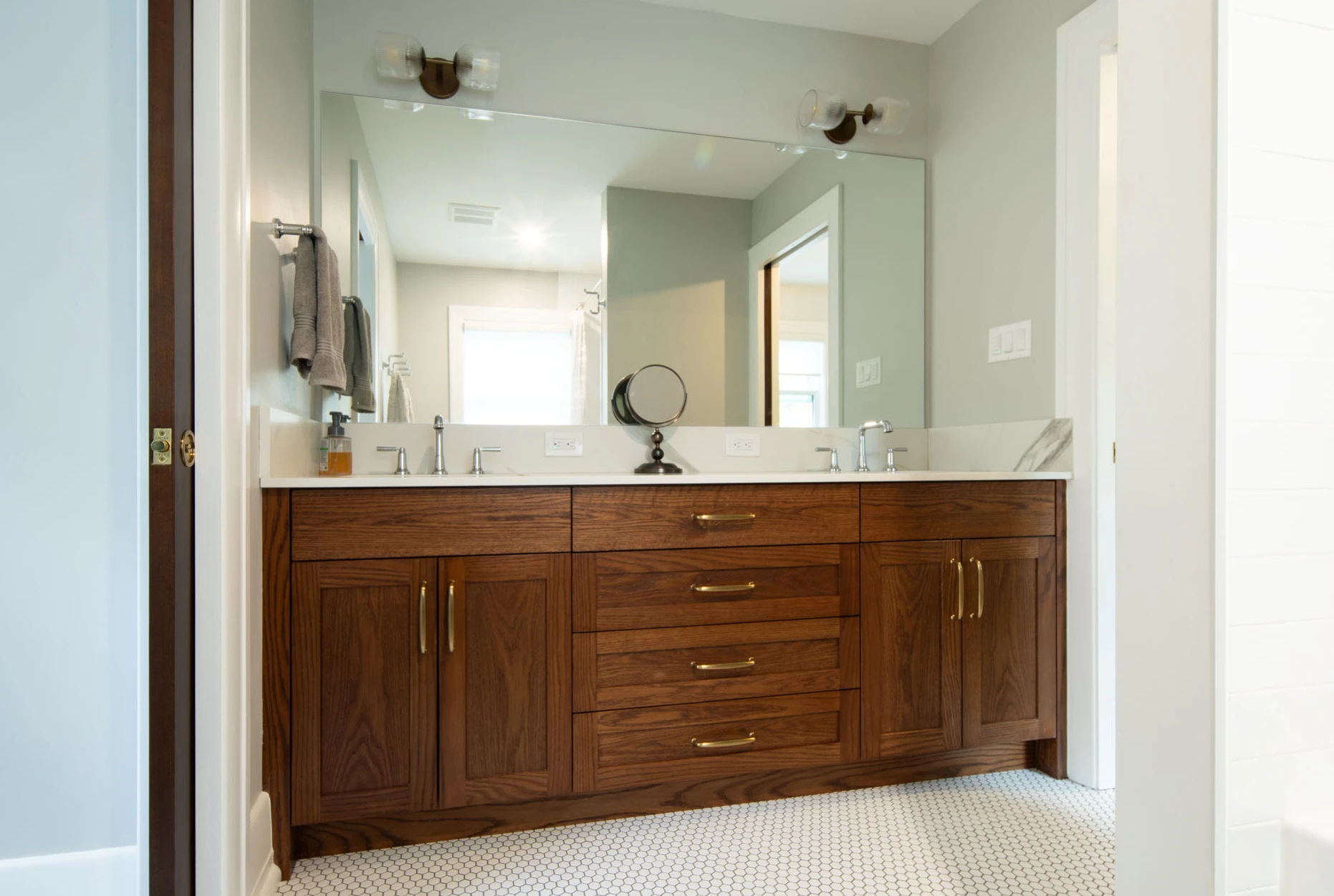 Solid wood bathroom vanity with double sink and brass drawer pulls. 