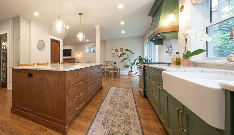 Brightly lit open-concept kitchen with solid wood flooring and cabinetry, granite countertops