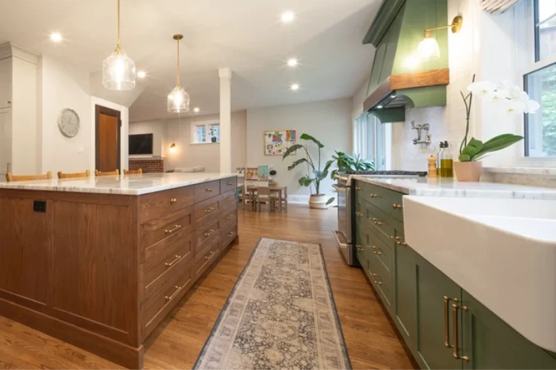 Brightly lit open-concept kitchen with solid wood flooring and cabinetry, granite countertops