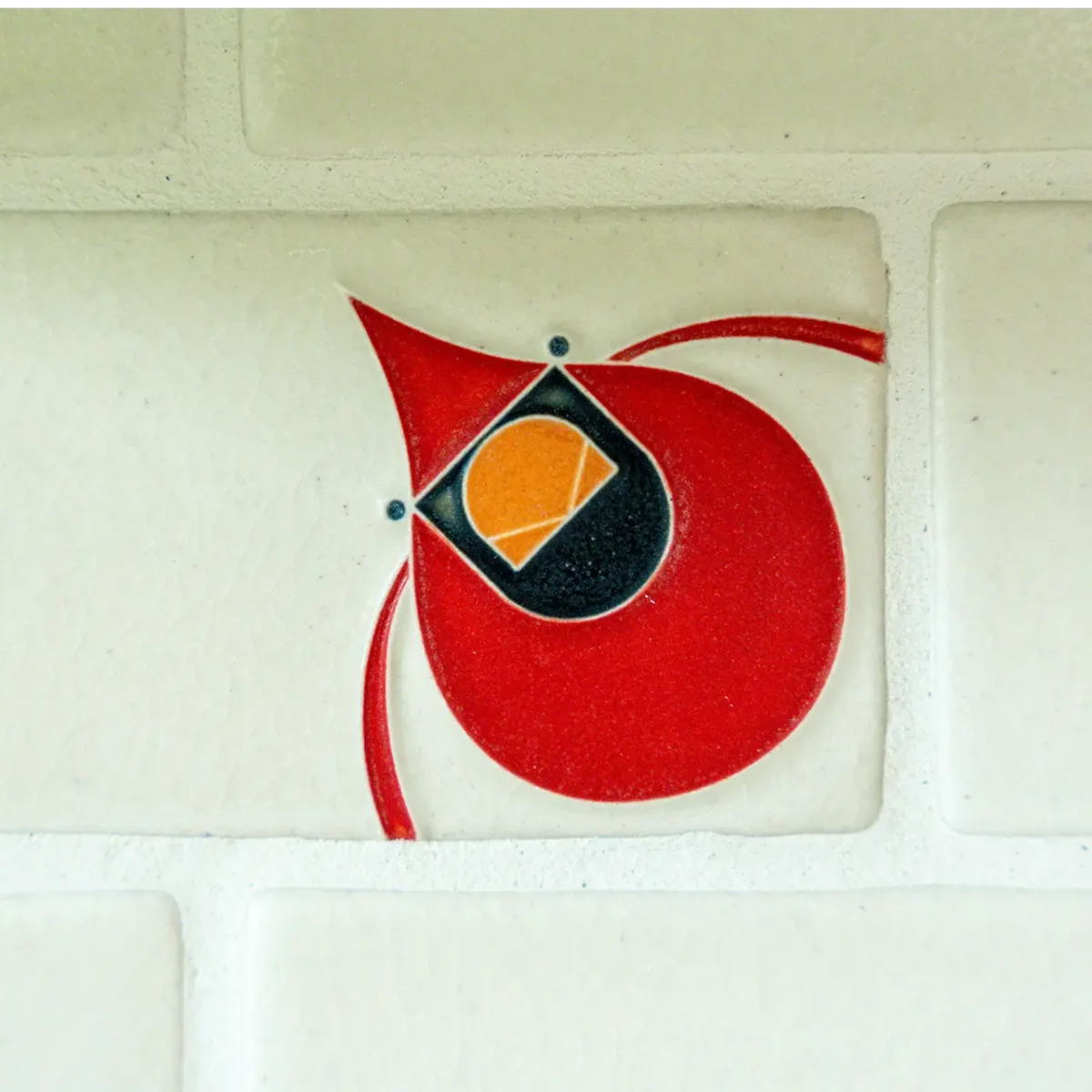 Close up shot of custom kitchen backsplash tile with red cardinal on it