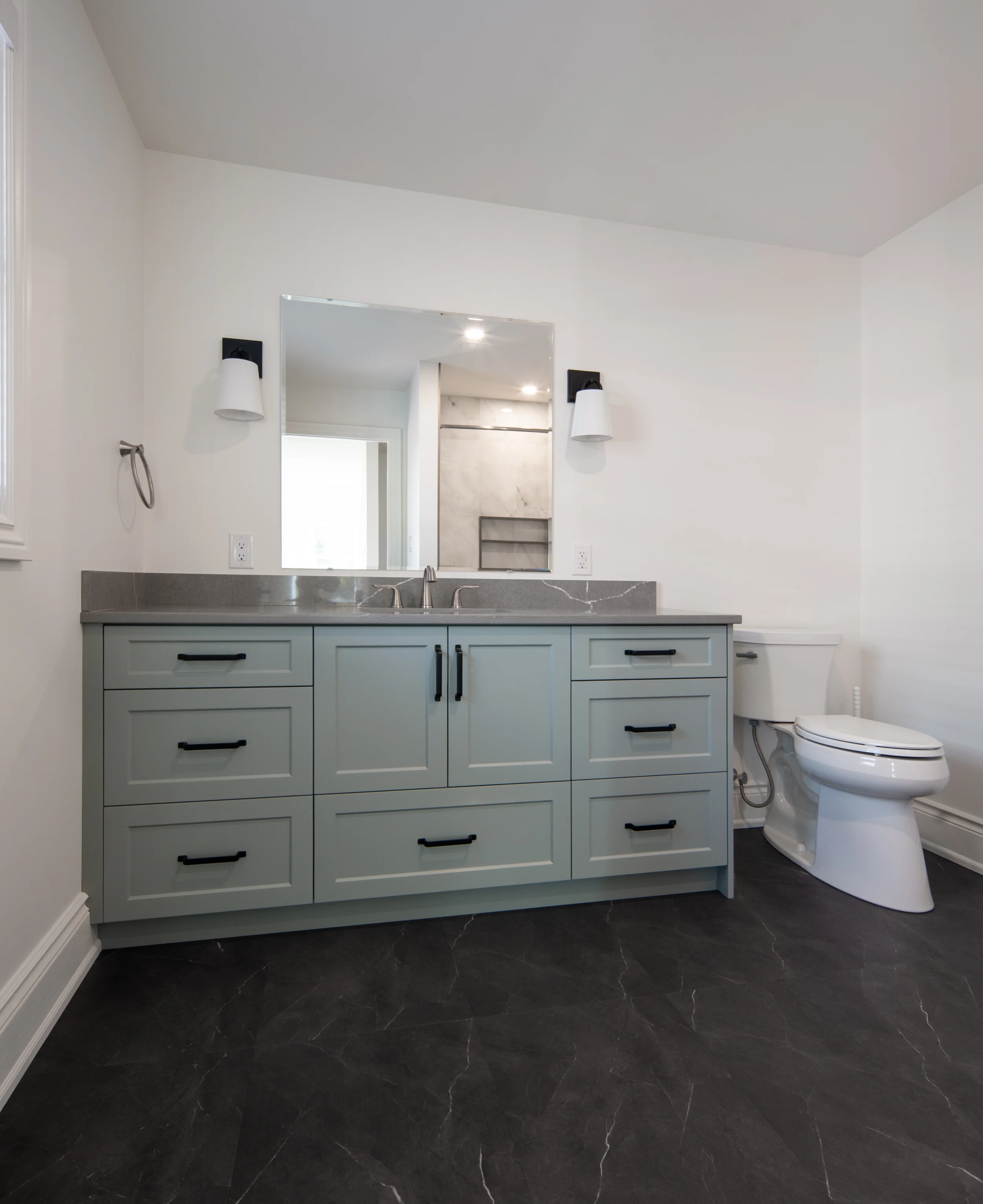large bathroom space with countertops, cabinets, sinks, and toilet